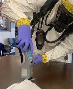 Handheld ResQ in use on table with envelope and white powder.