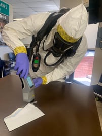 Handheld ResQ in use on table with envelope and white powder.